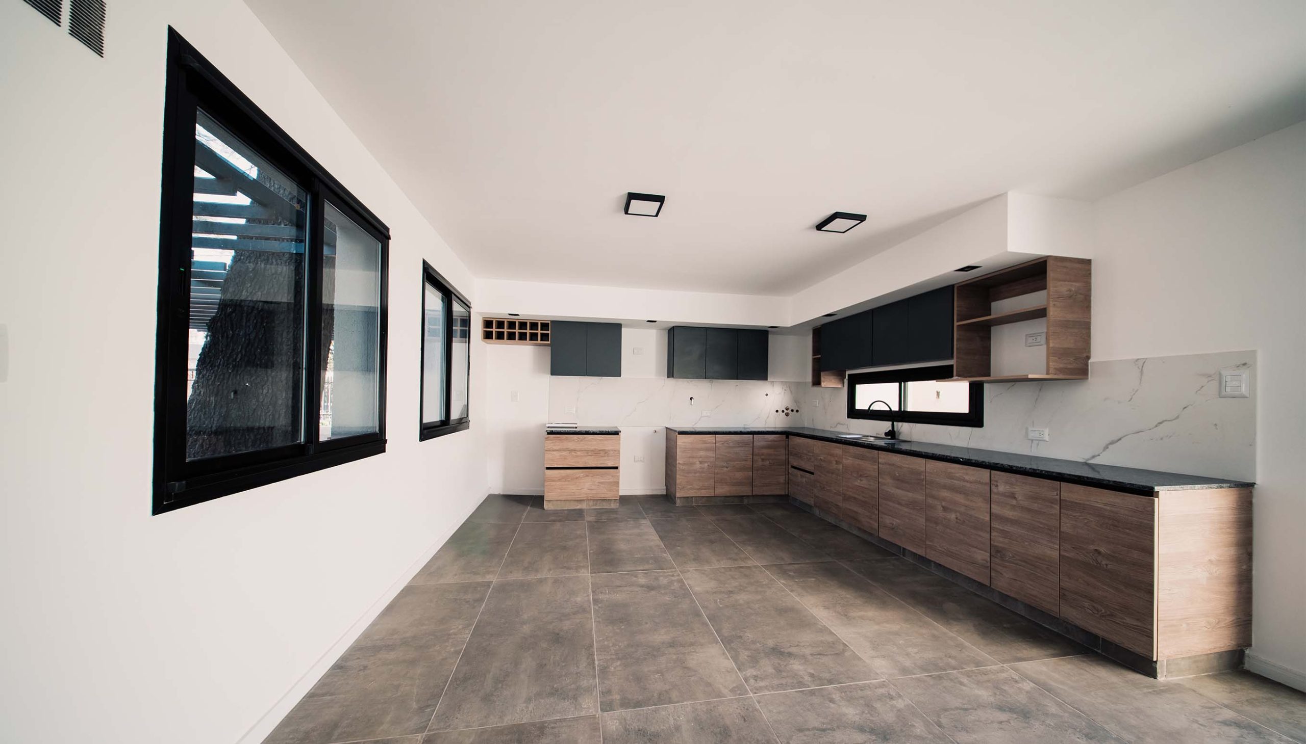 foto cocina abierta y living al lado del patio interno de casa en vitta housing desarrollada por filomeni